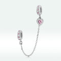 Silver charm with pink stones on a white background