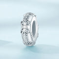 Silver ring with intricate design on a light blue background
