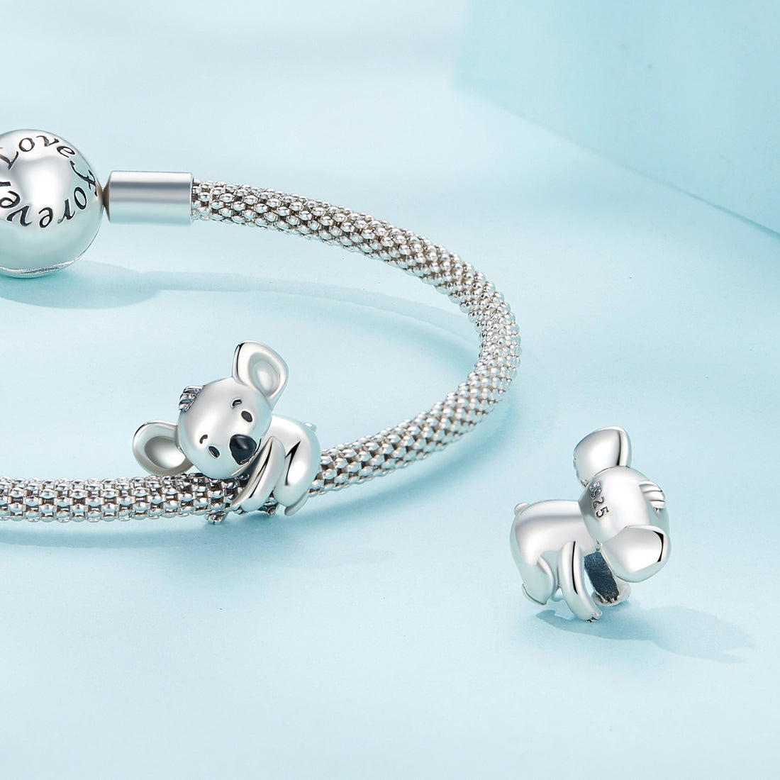 Silver koala charm on a light blue background