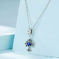 Silver necklace with a blue gemstone pendant on a light blue background