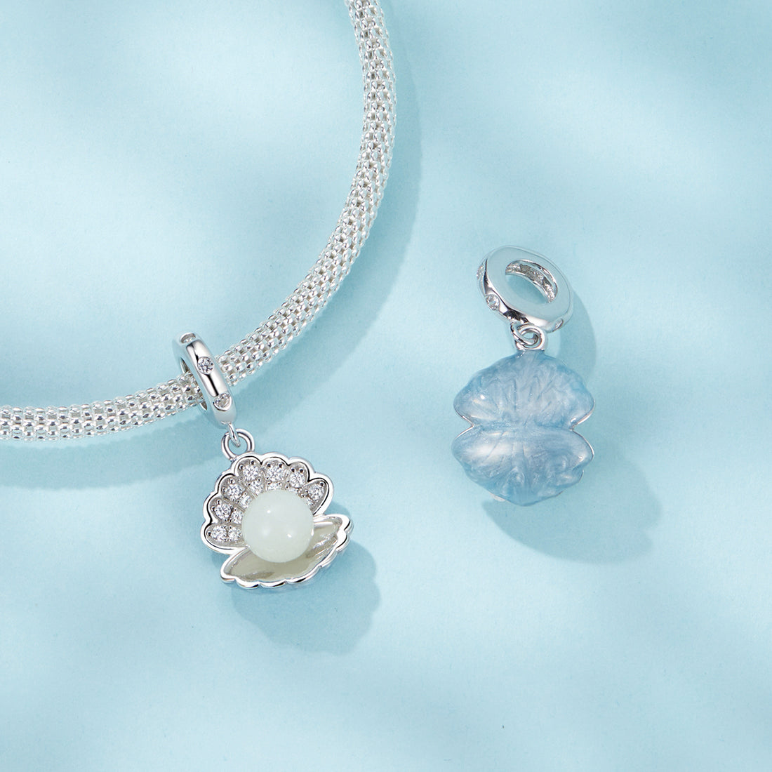Silver pendant with a pearl on a light blue background