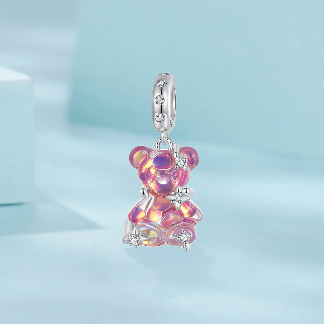 Pink teddy bear charm on a light blue background