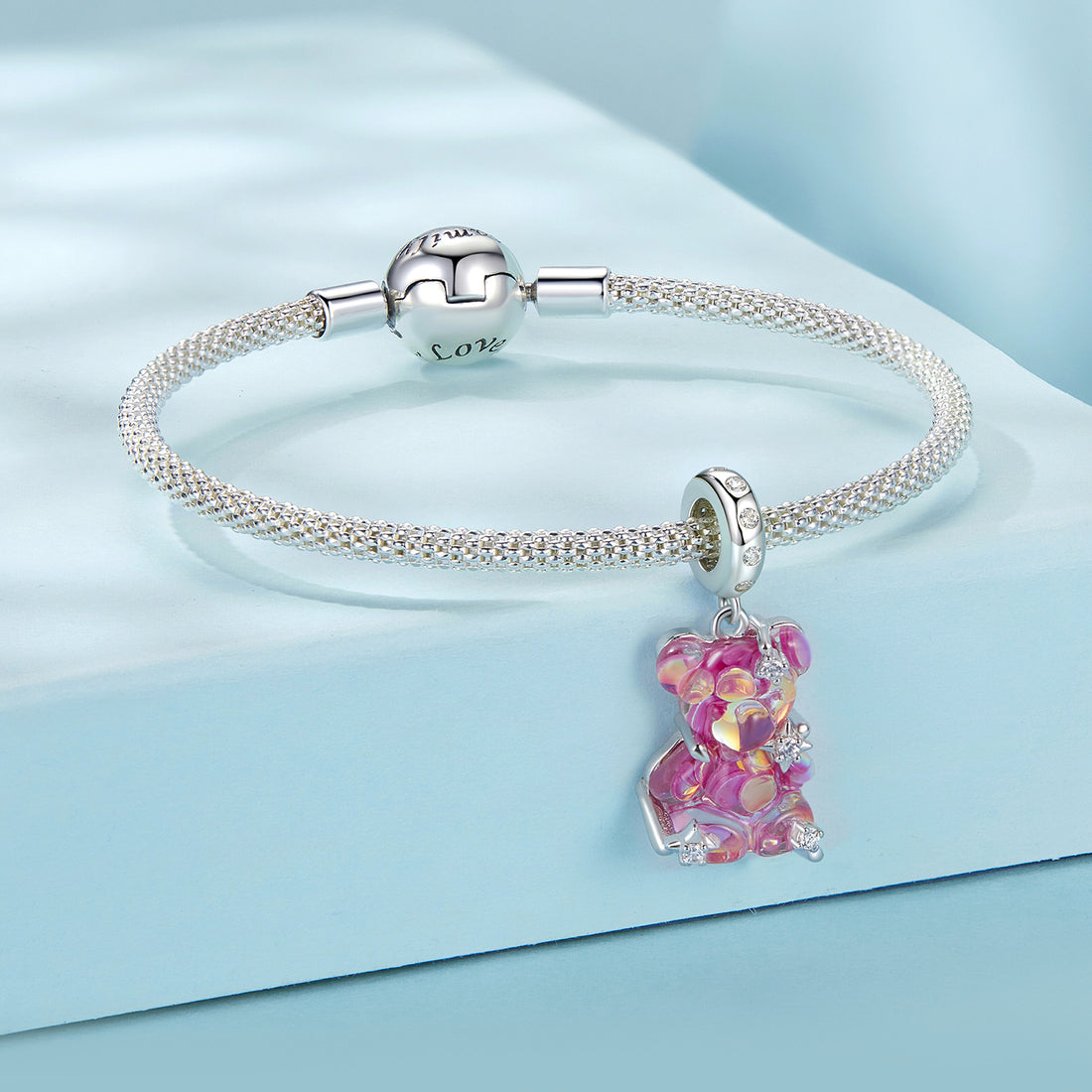 Pink teddy bear charm on a light blue background