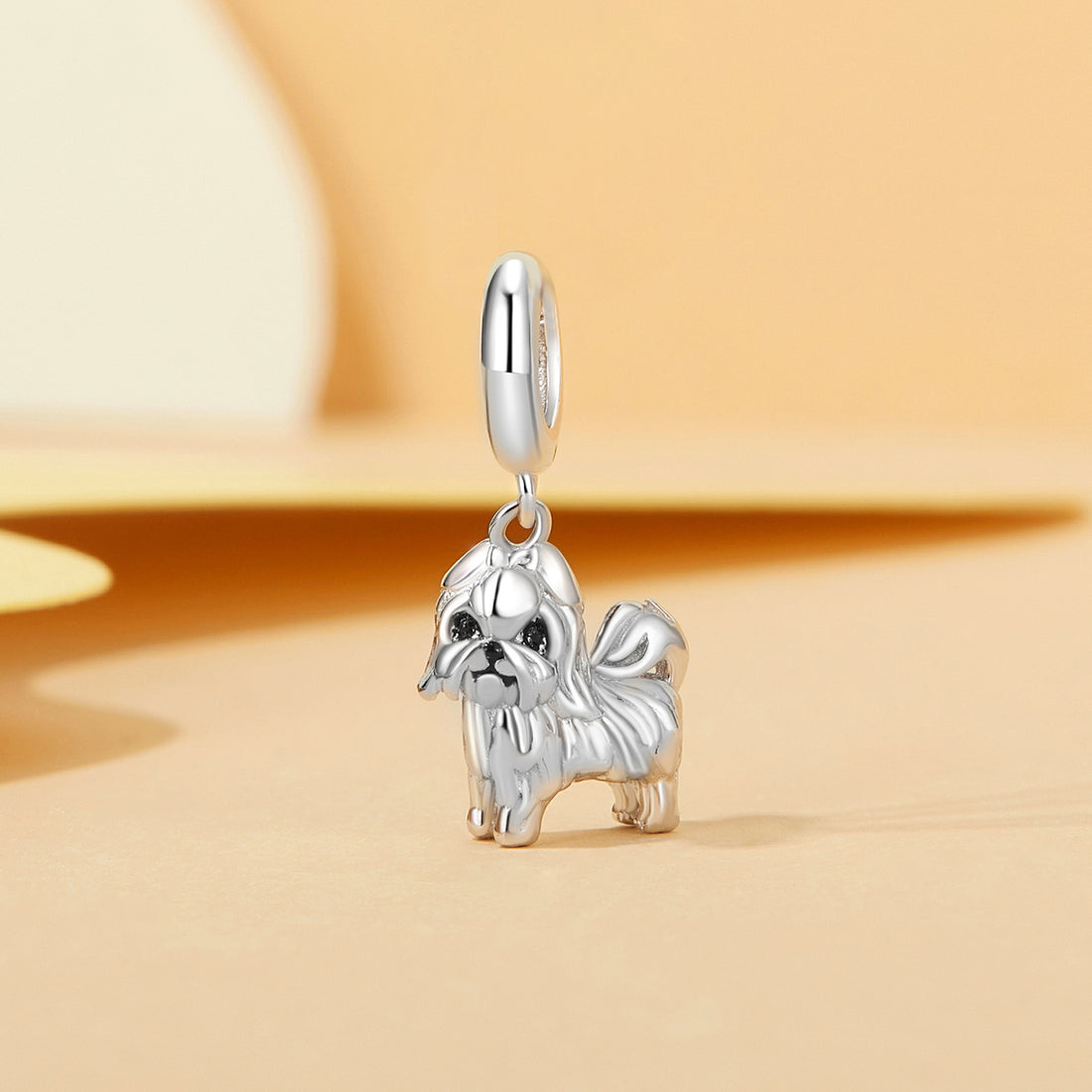 Silver dog-shaped pendant on a beige background