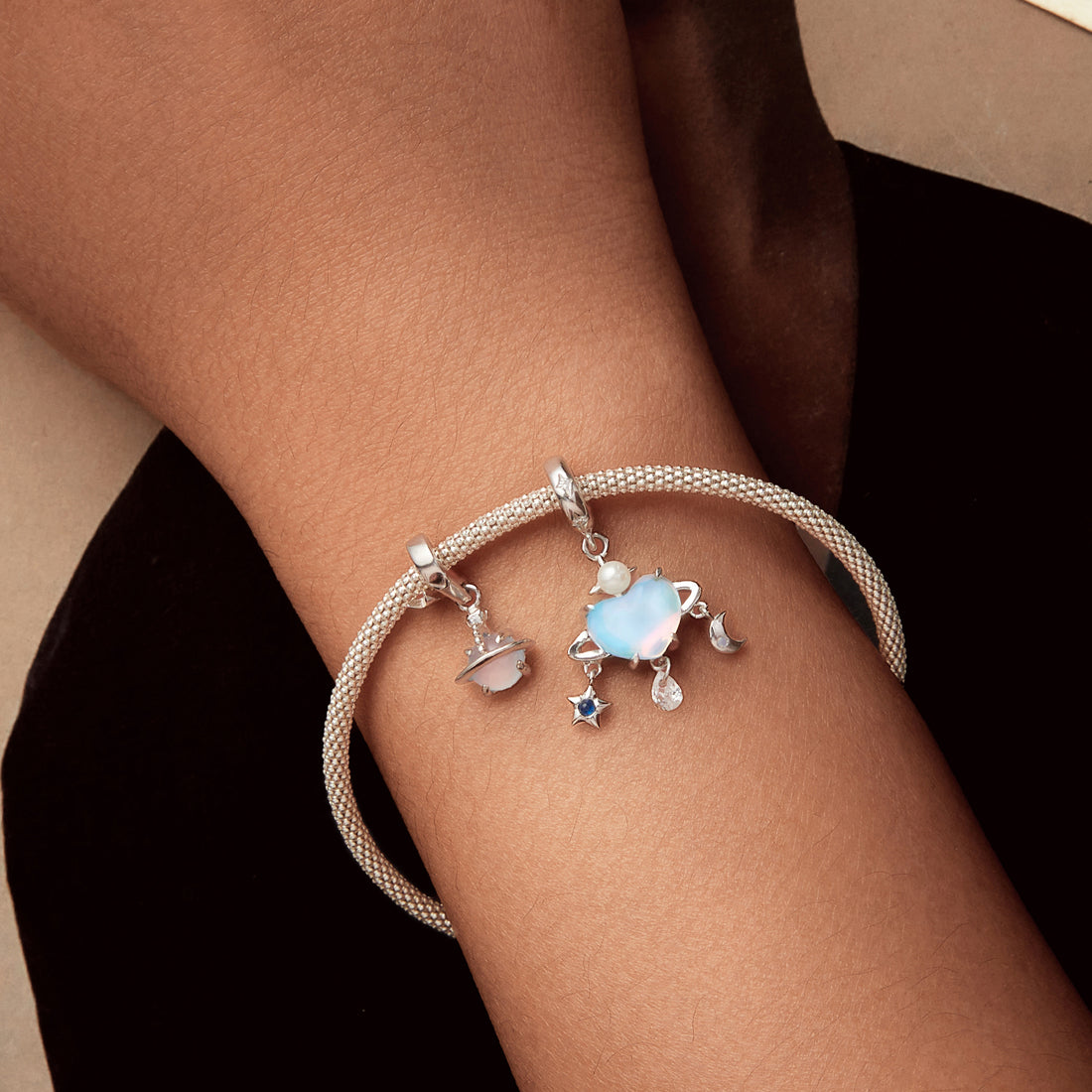 Silver charm with a heart, star, and moon on a white background