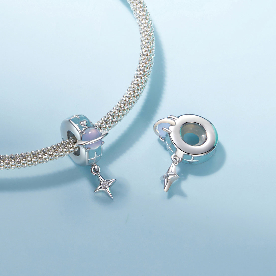 Jewelry charm with blue and silver design on a white background