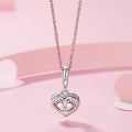 Silver heart-shaped necklace with footprints on a pink background