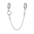 Silver earring with heart charm and chain on a white background