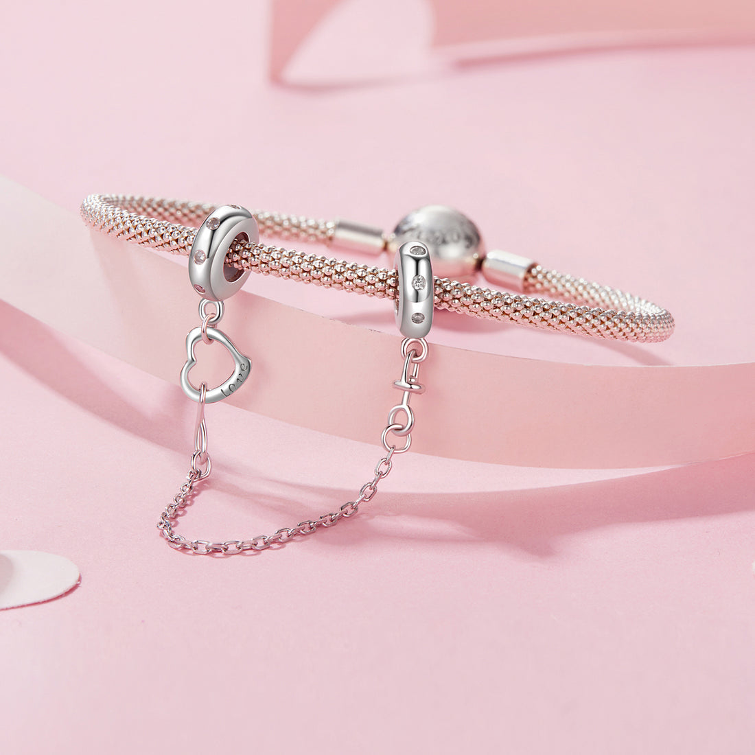 Silver earring with heart charm and chain on a white background