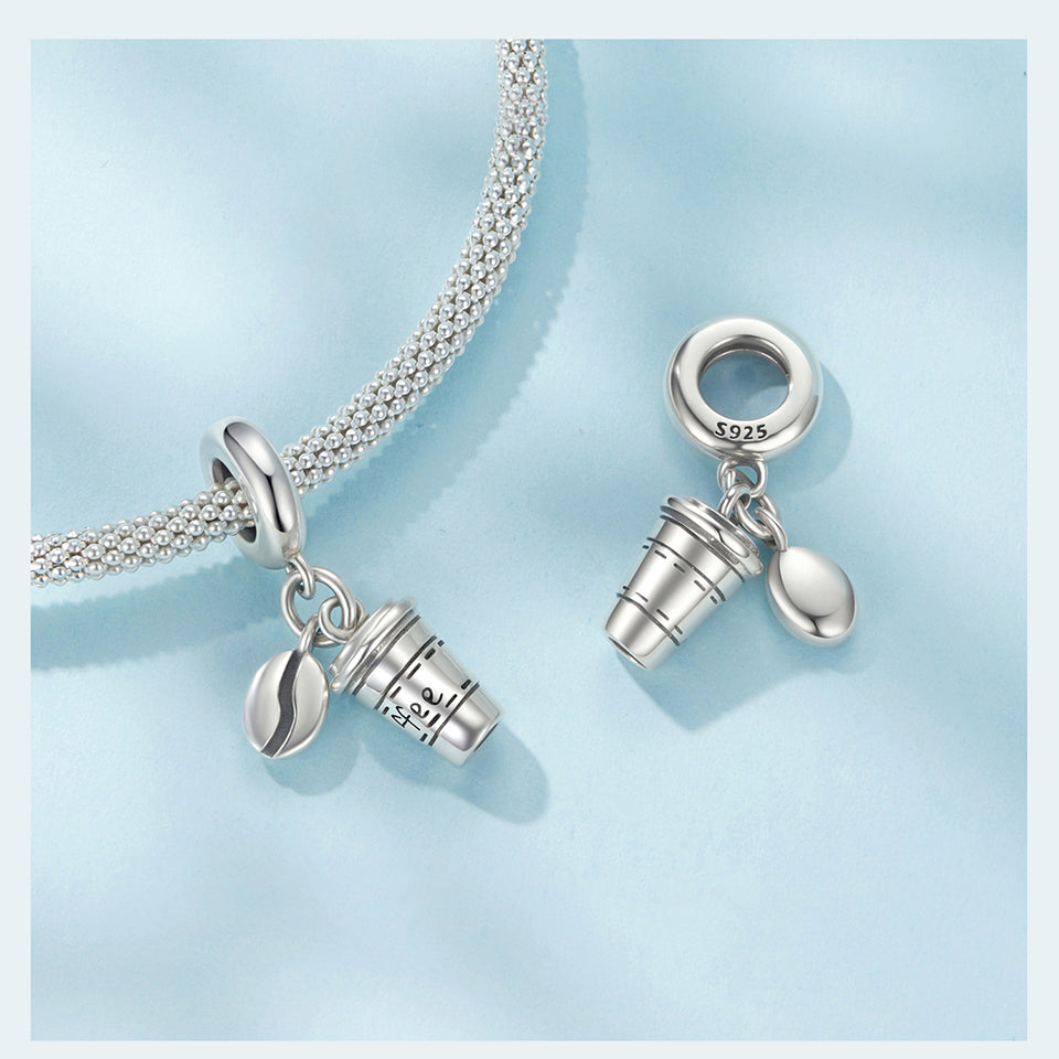Silver charm shaped like a coffee cup with 'Coffee' text on a light blue gradient background