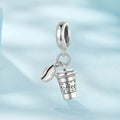 Silver charm shaped like a coffee cup with 'Coffee' text on a light blue gradient background