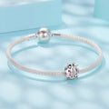 Silver bracelet with a ladybug charm on a light blue background