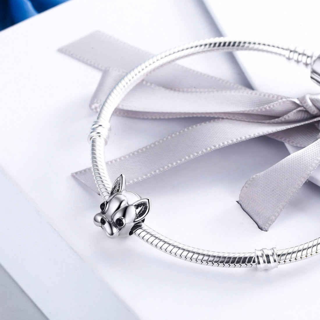 Silver bracelet with a detailed charm on a white background