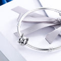 Silver bracelet with a detailed charm on a white background