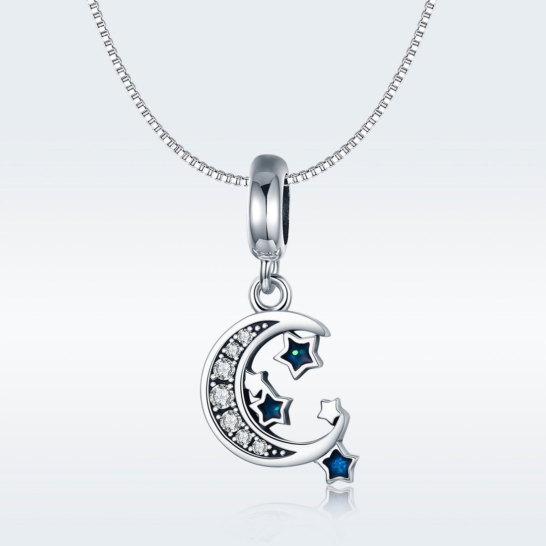 Silver pendant with moon and star design on a light gray background