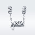Silver cat charm on a chain with a white background