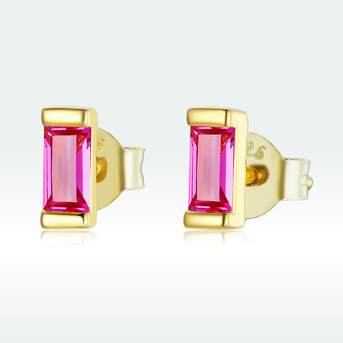 Gold earrings with pink gemstones on a white background