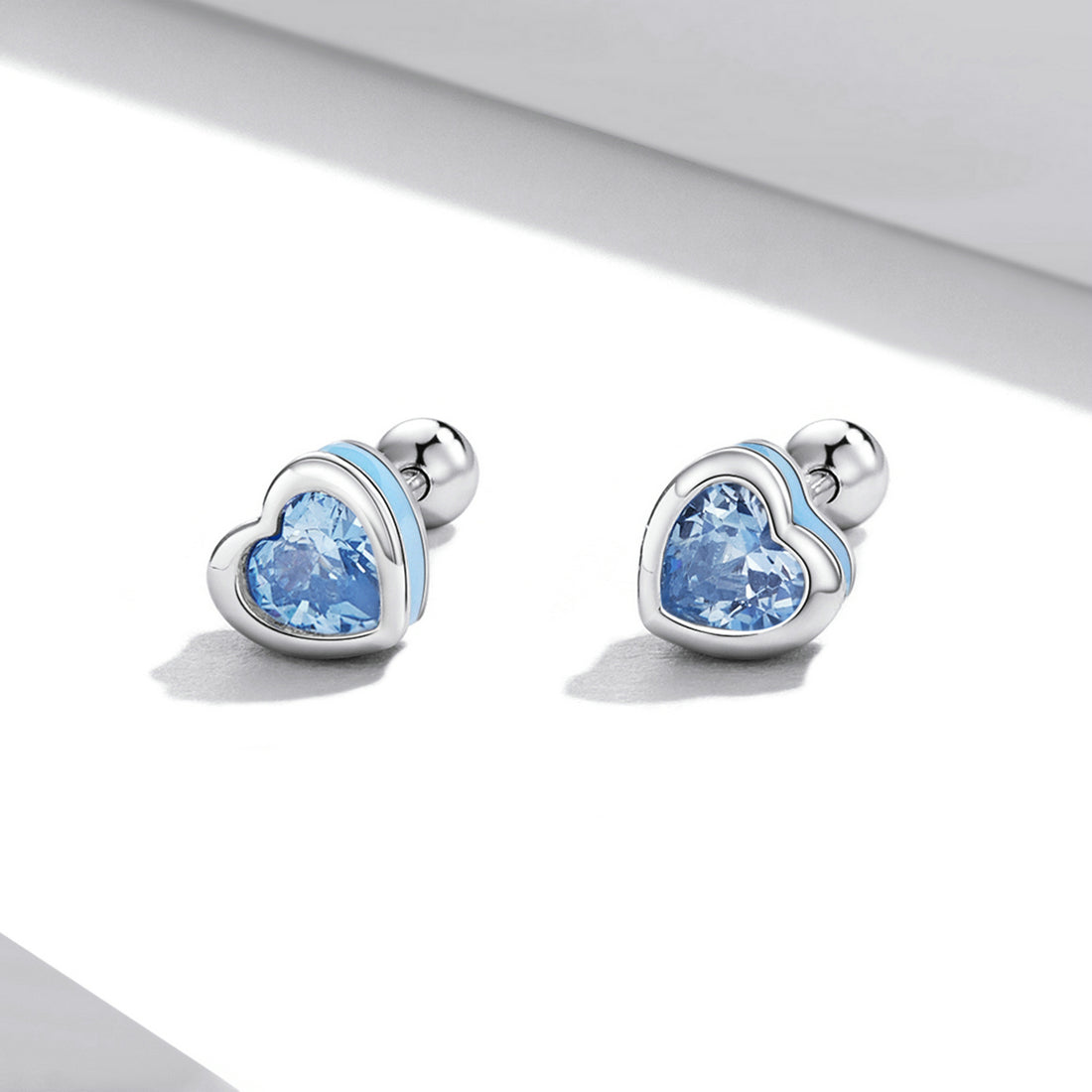Heart-shaped earrings with blue gemstones on a white background