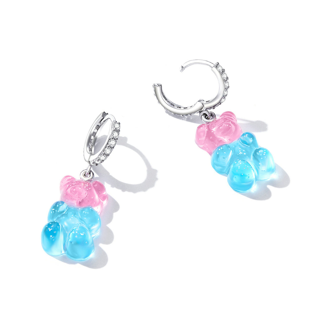 Gummy bear-shaped earrings with blue bodies and pink cheeks on a white background