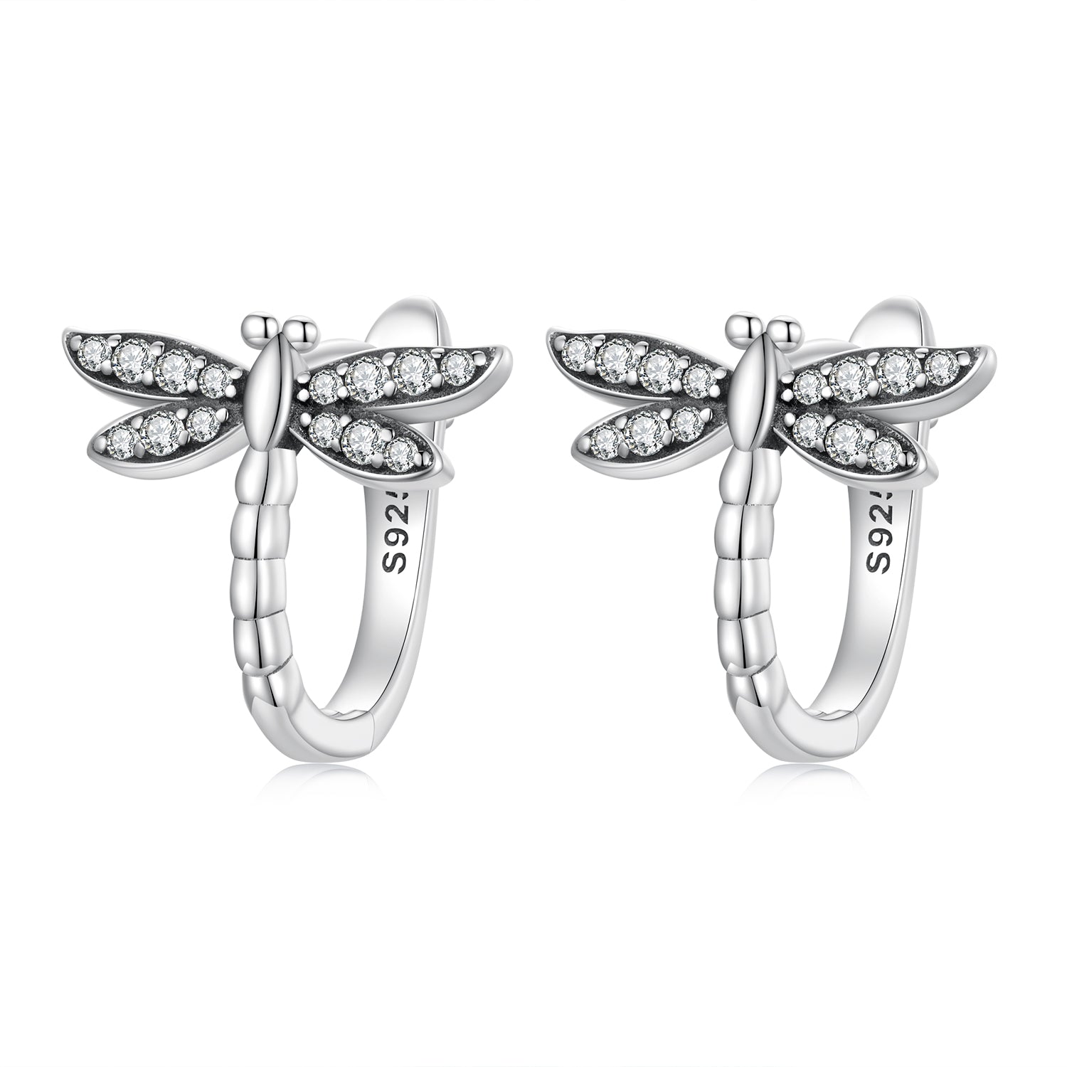 Silver dragonfly-shaped earrings with clear gemstones on a white background
