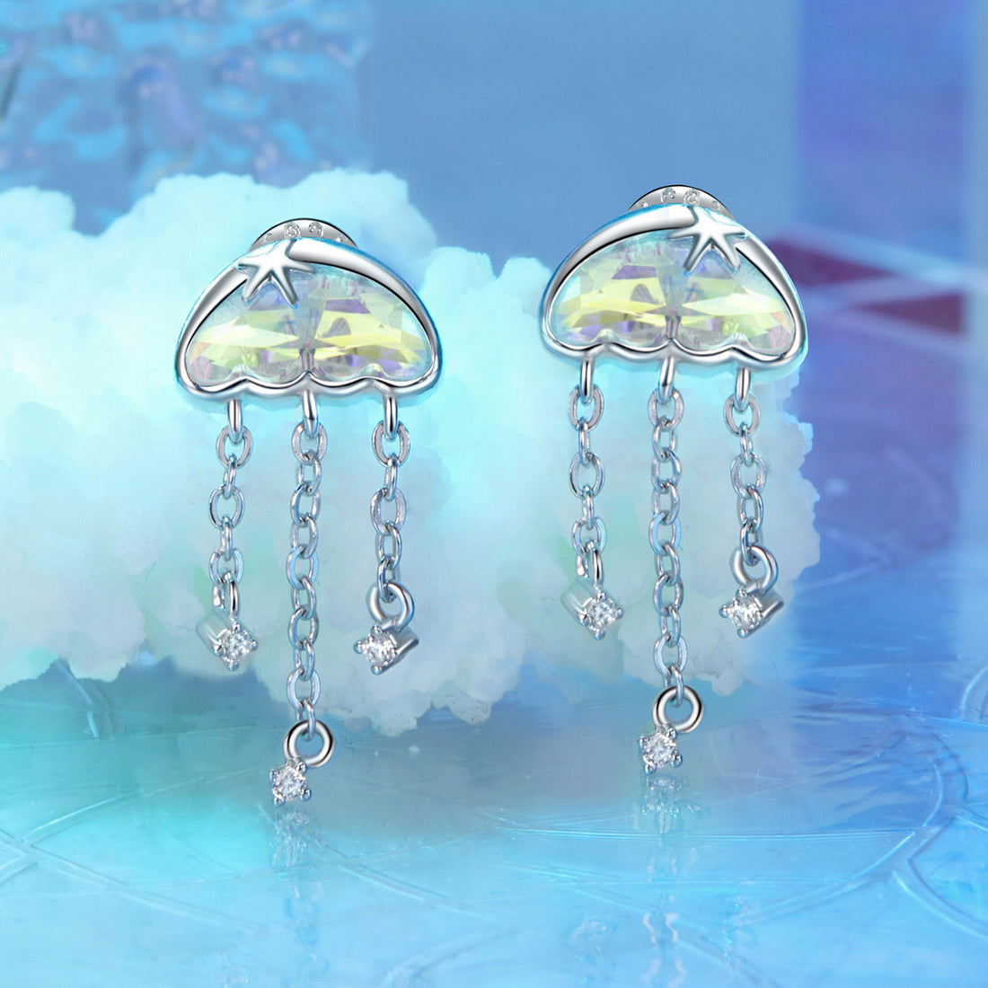 Heart-shaped cloud earrings with dangling crystals on a white background
