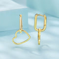 Gold heart-shaped earrings on a light blue background