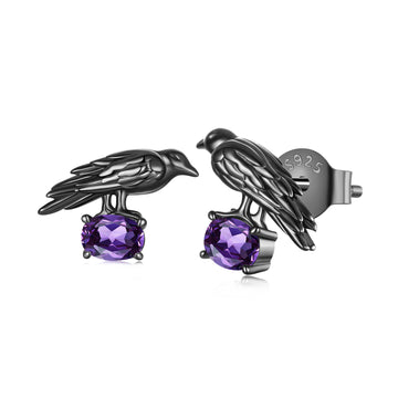 Black bird-shaped earrings with purple gemstones on a white background