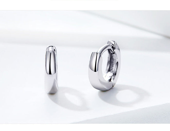 Silver hoop earrings on a white background with a motivational quote.