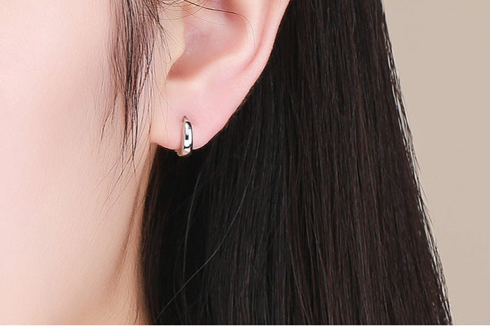 Silver hoop earrings on a white background with a motivational quote.