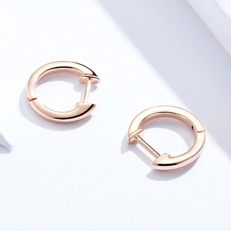 Rose gold hoop earrings on a light background