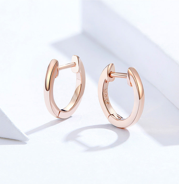 Rose gold hoop earrings on a light background