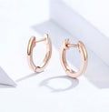 Rose gold hoop earrings on a light background
