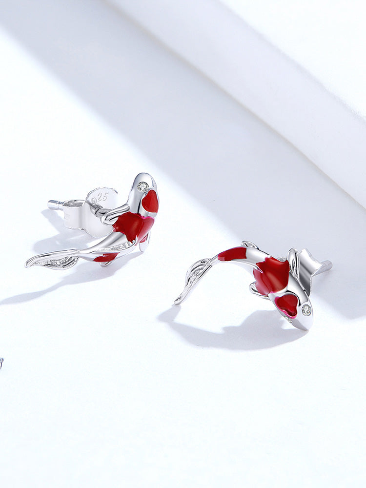 Pair of red and silver fish-shaped earrings on a white background