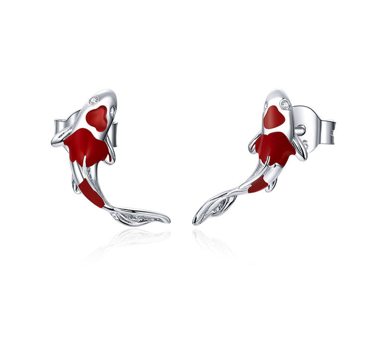 Pair of red and silver fish-shaped earrings on a white background