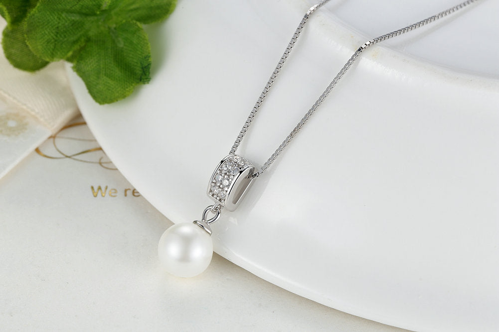 Pearl necklace with diamond pendant on a white background