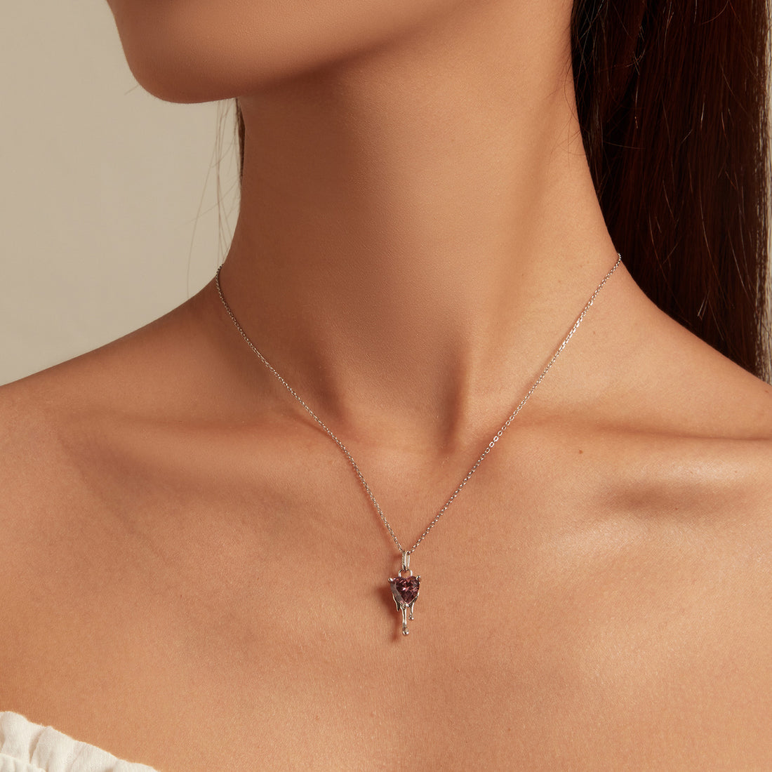 Heart-shaped pink gemstone pendant on a white background