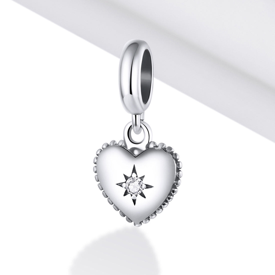 Silver heart-shaped pendant with a star design on a white background