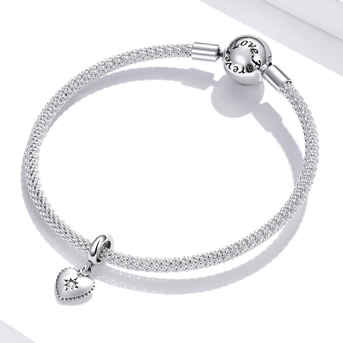 Silver heart-shaped pendant with a star design on a white background