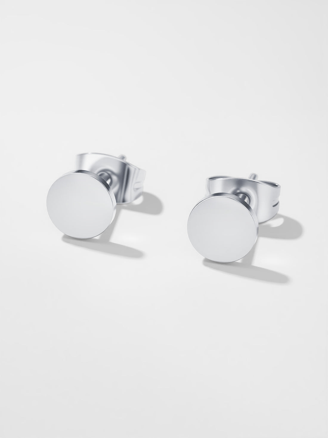 Silver round earrings on a white background