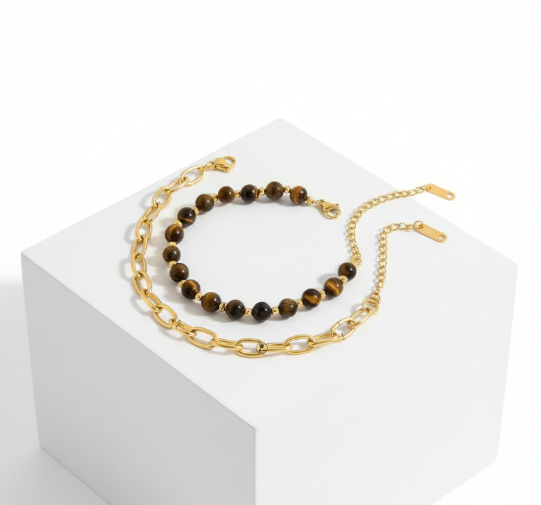 Gold chain necklace with black beads on a white background